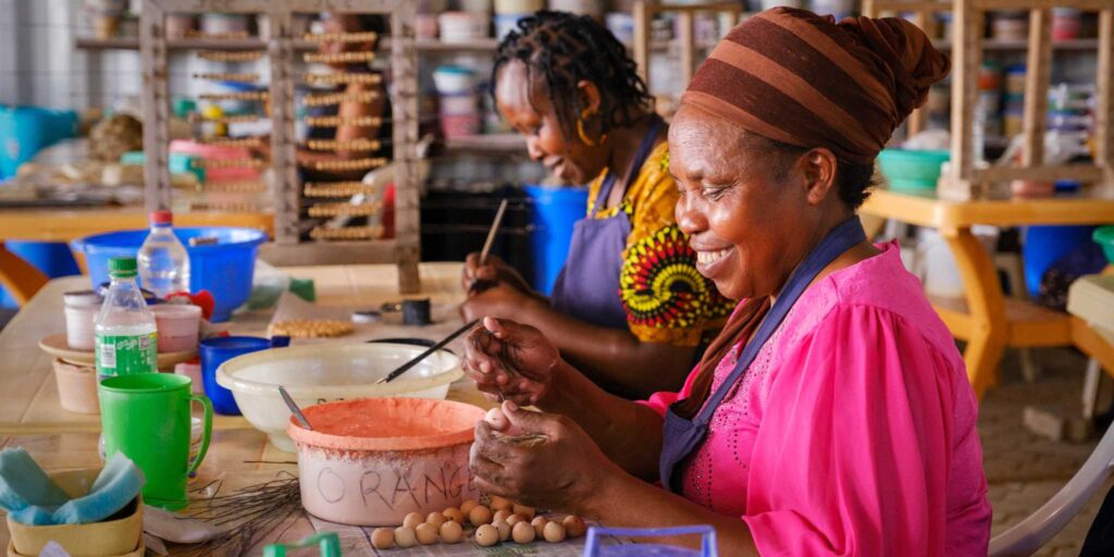 Two women painting beads on the Kenya Women's only tour workshops