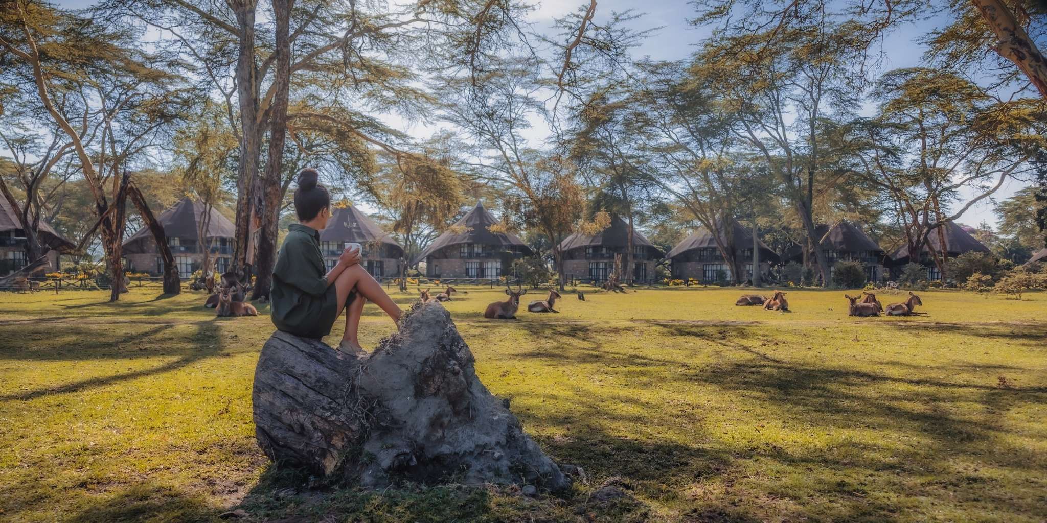 A woman sat on a rock looking peacefully at the wildlife at Lake Naivasha Sopa Lodge