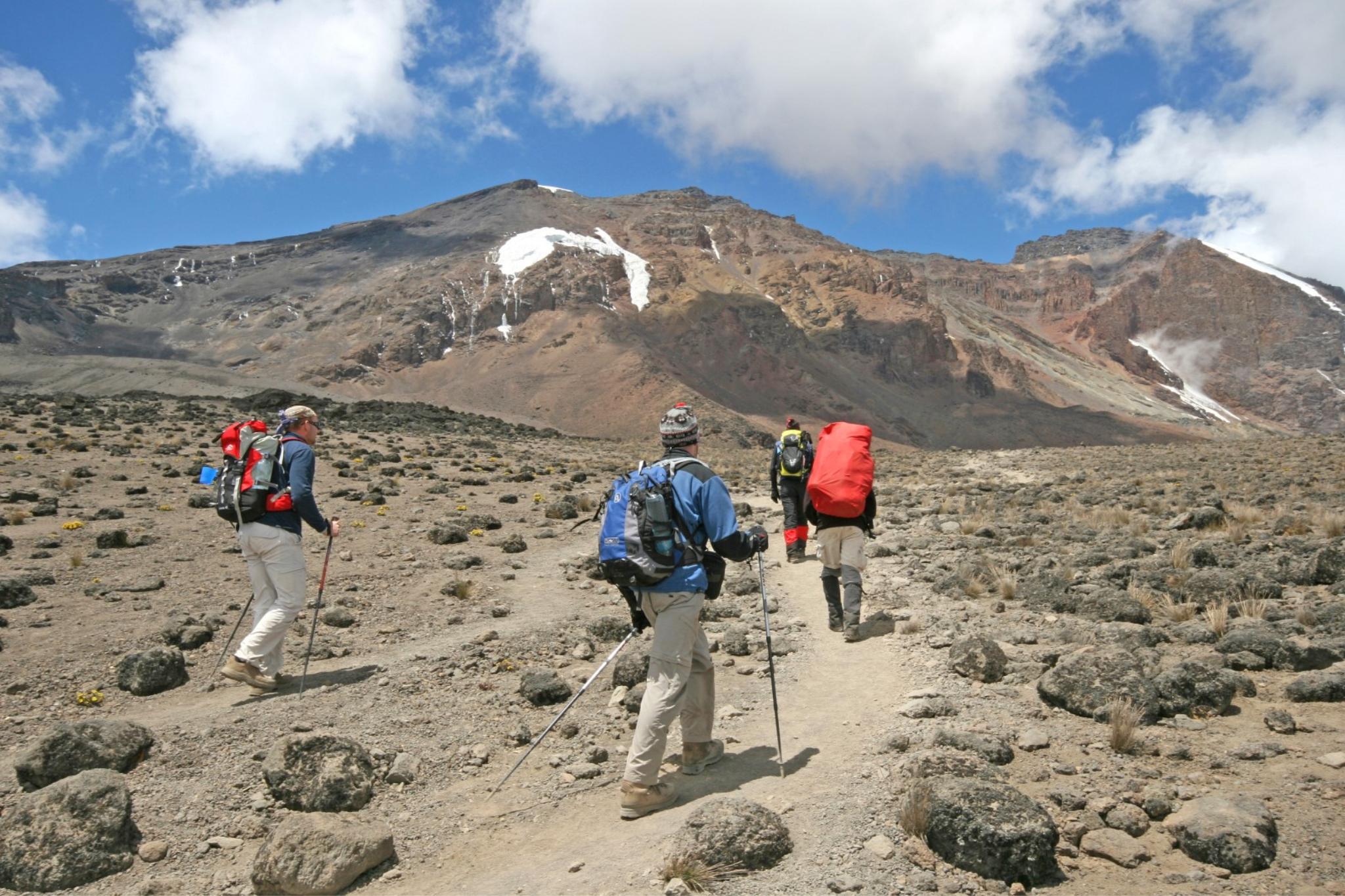 three people trekking up Mount Kilimnajaro