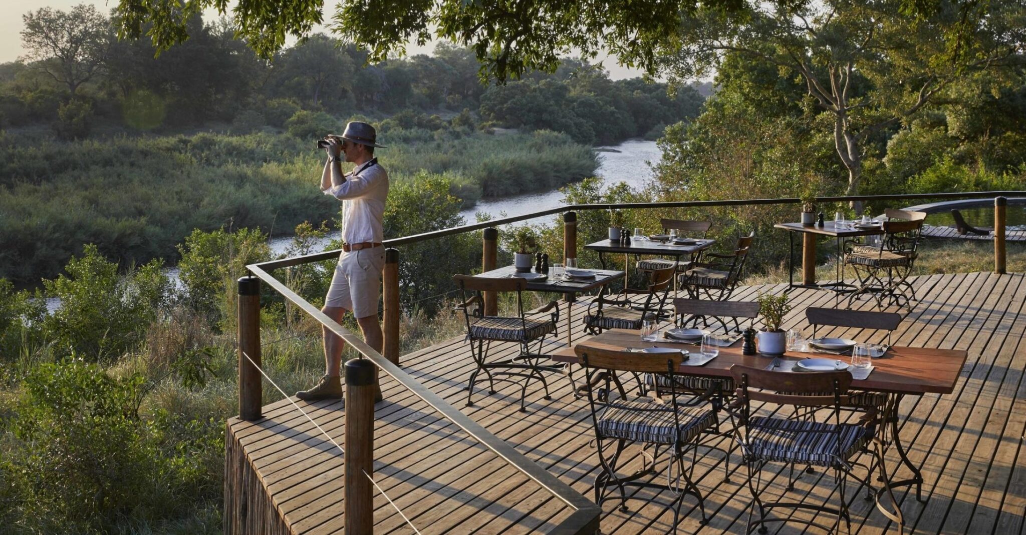 Man looking through binoculars at the gorgeous view from the Lion Sands Tinga Lodge