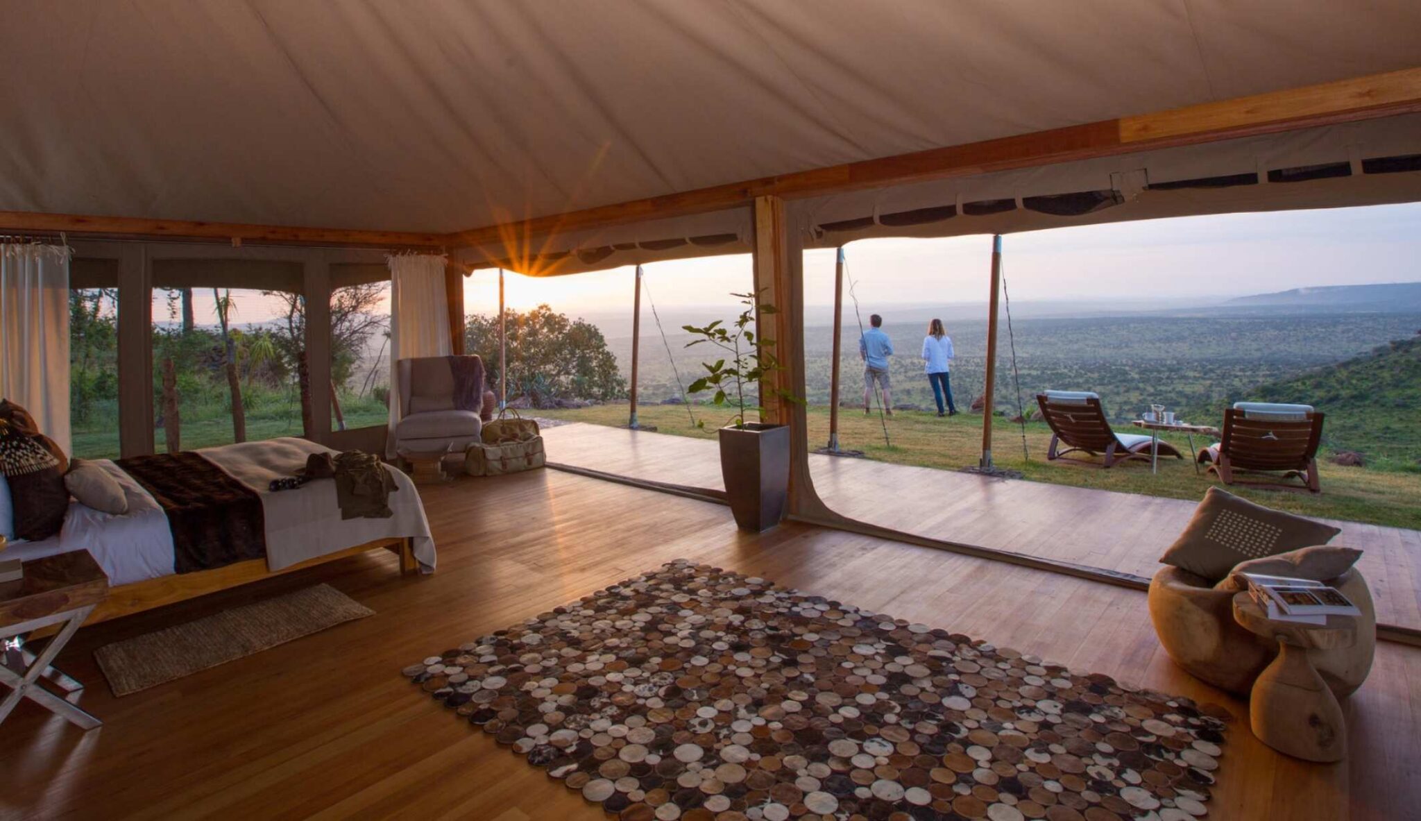 Luxury safari tent with open views of the savannah at sunset.