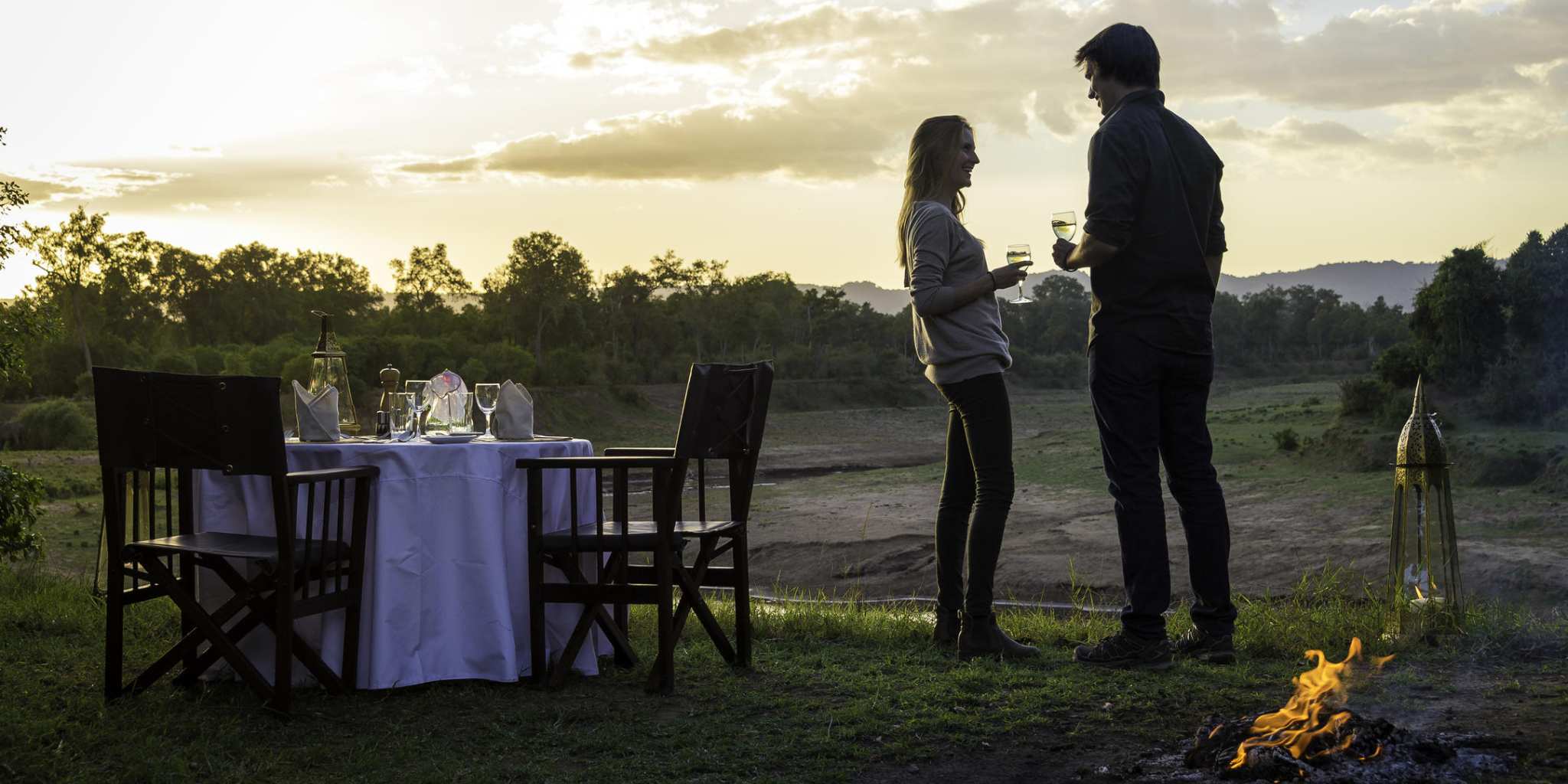 Couple enjoying private bush dinner at Governors Il Moran Camp