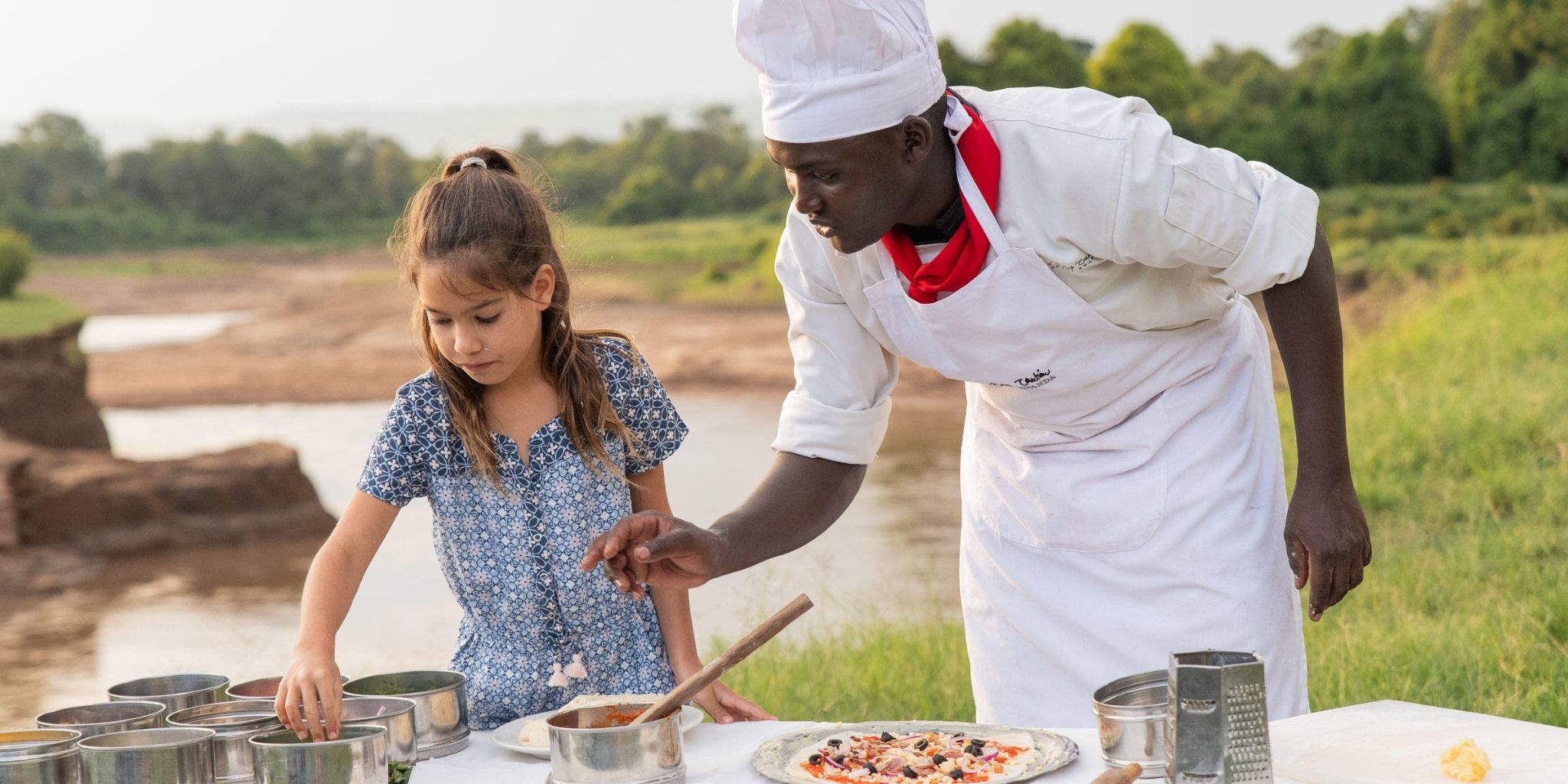 Young girl learning to cook outside surrounded by nature as part of the Mongoose Club at Governors Camp.