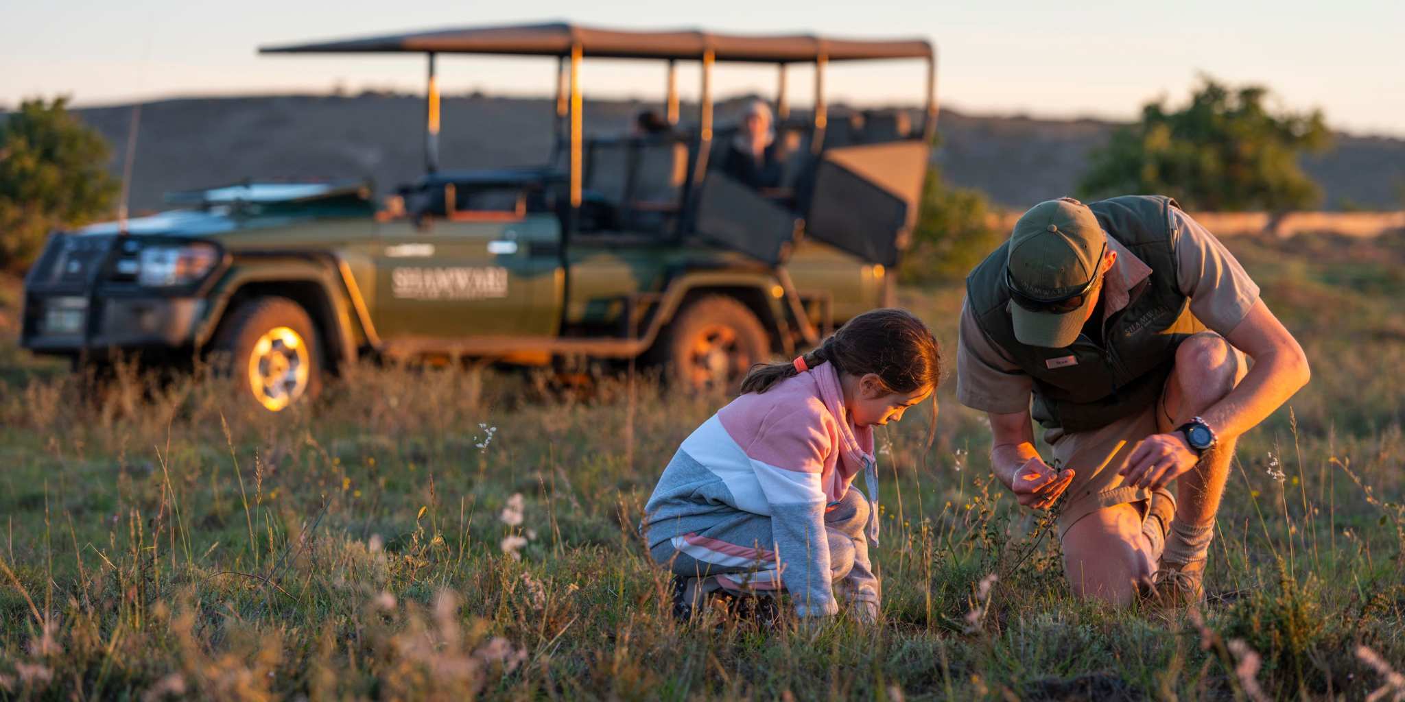 Guide showing a child flowers on safari