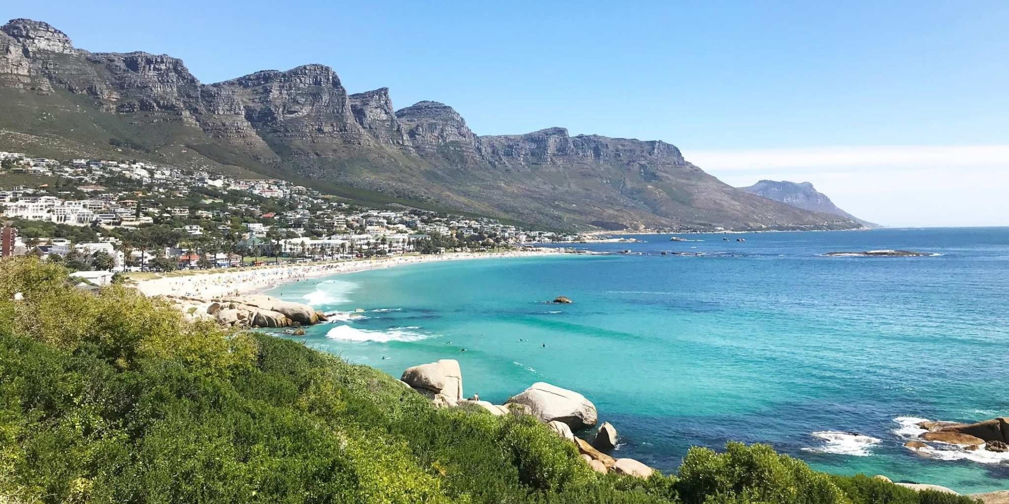 View of Clifton beach with bright blue sea surrounded by dramatic cliffs and white sand