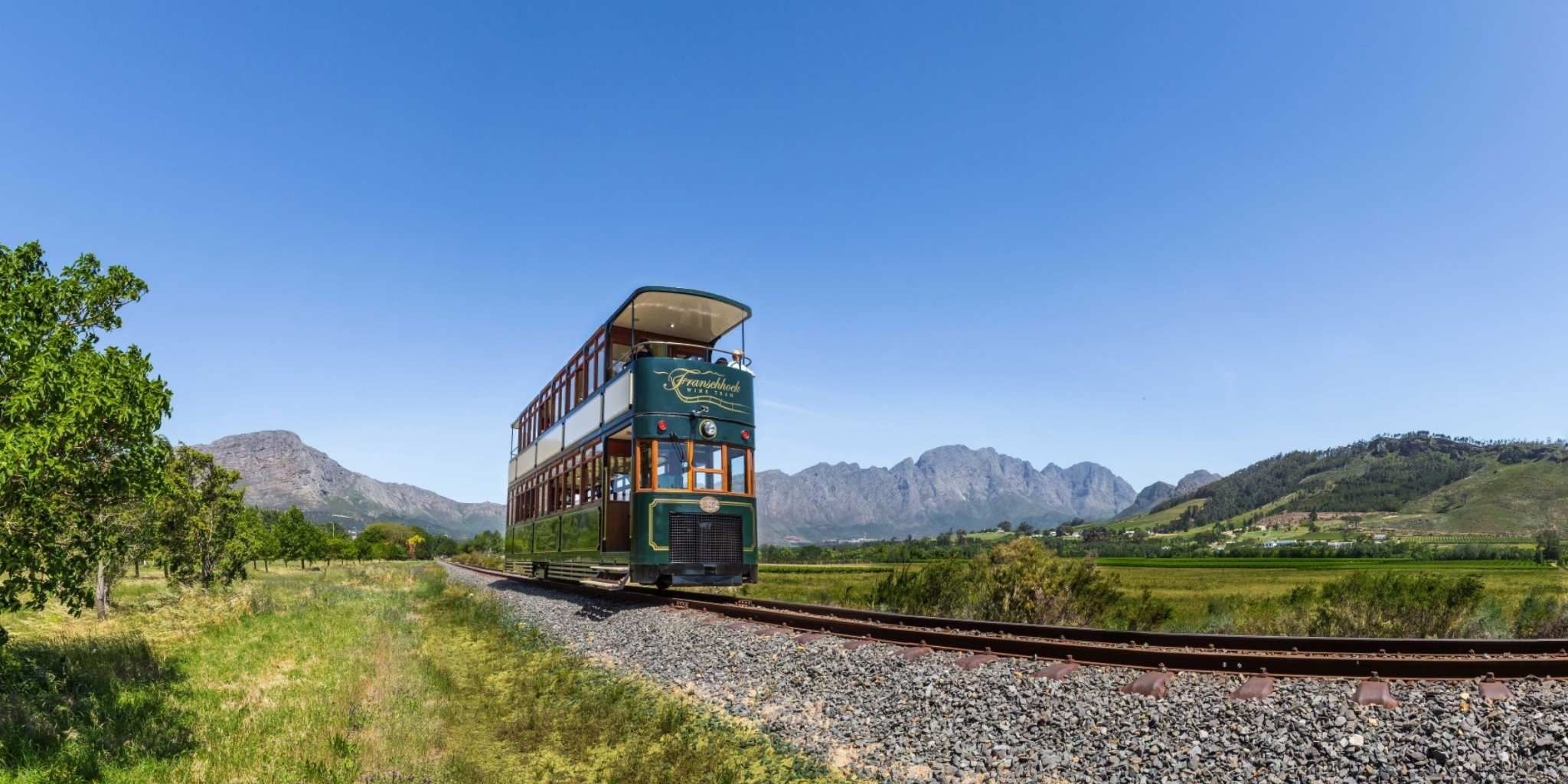 Vinatge looking Wine Tram surrounded by stunning scenery of green and mountains