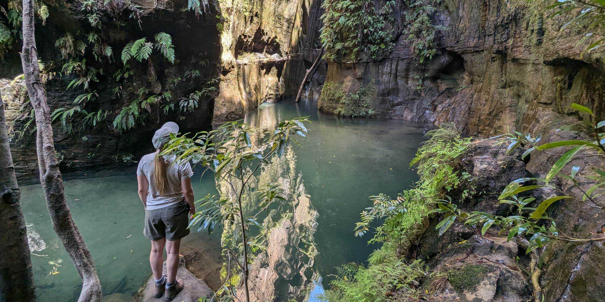Woman standing by some caves and gorgeous blue water