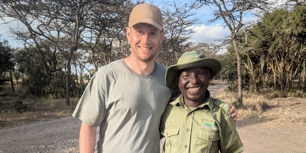 Ben Dessen and safari guide standing together smiling for a photo