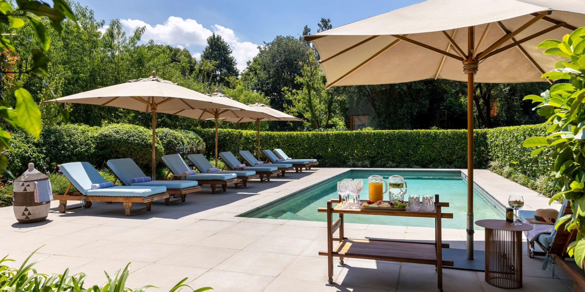 Luxurious outdoor pool surrounded by sun loungers at The Peech 