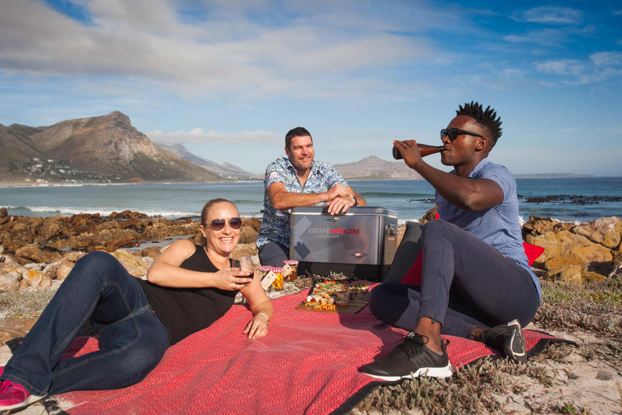 A couple picnicking on the beach with a guide in Cape Town, South Africa